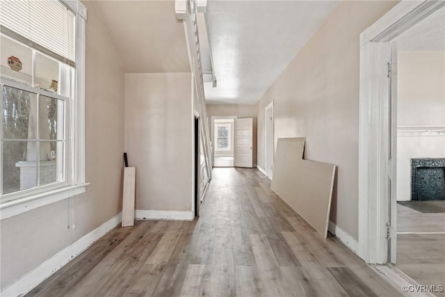 hall featuring light wood finished floors and baseboards