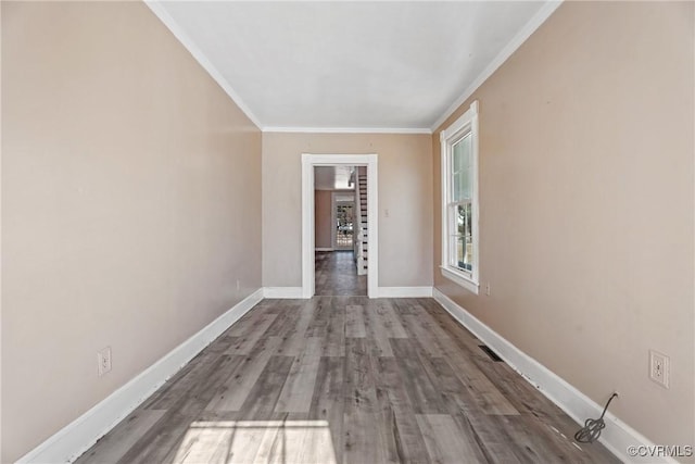 hall with visible vents, crown molding, baseboards, and wood finished floors