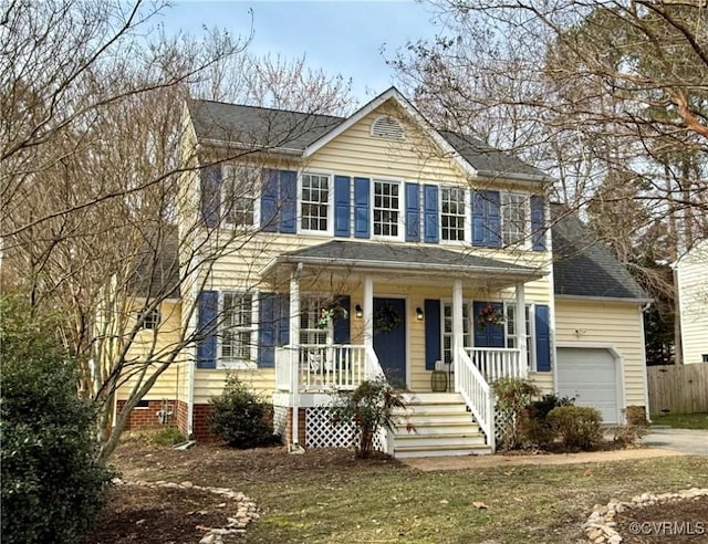 colonial inspired home with roof with shingles, covered porch, an attached garage, crawl space, and fence