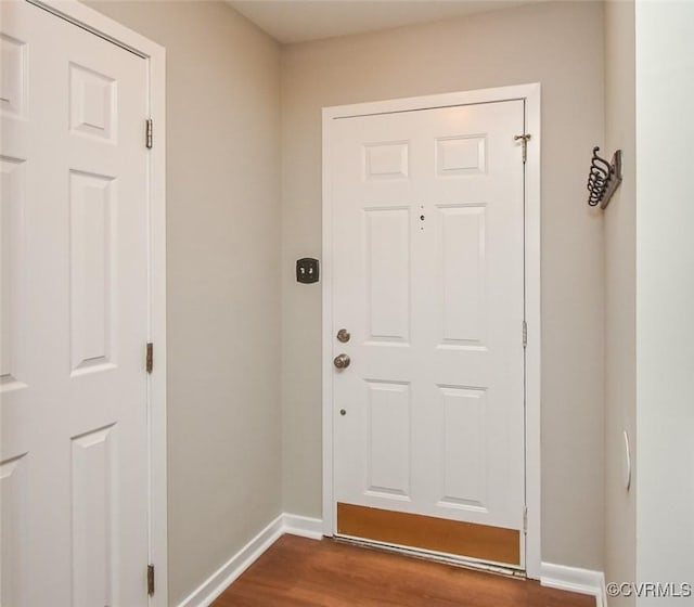 entryway with dark wood-style floors and baseboards