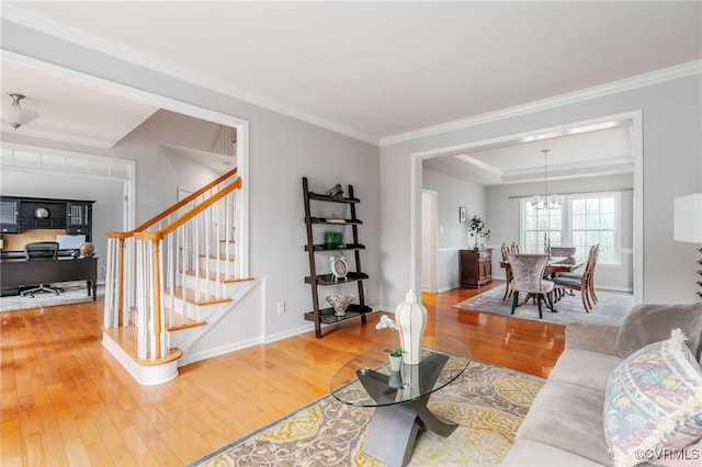 living room featuring baseboards, stairway, wood finished floors, and crown molding