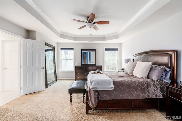 bedroom featuring multiple windows, a tray ceiling, carpet flooring, and ornamental molding