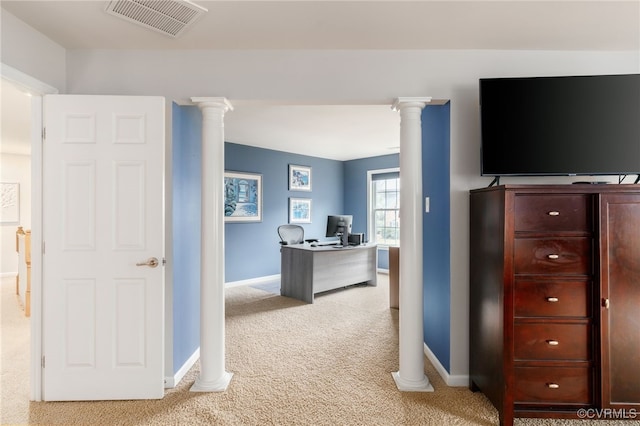 office space featuring decorative columns, visible vents, baseboards, and light colored carpet