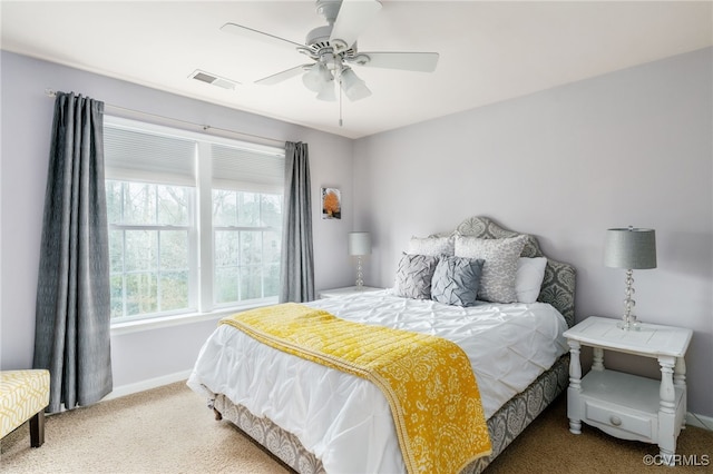 carpeted bedroom with baseboards, visible vents, and a ceiling fan