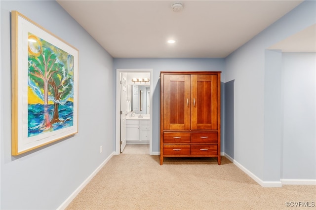 unfurnished bedroom featuring light carpet, recessed lighting, connected bathroom, and baseboards