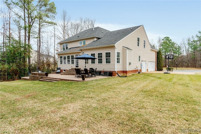 rear view of property with a garage, a patio area, and a yard