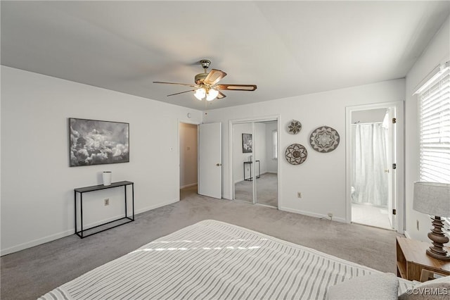 bedroom with ceiling fan, connected bathroom, light colored carpet, baseboards, and a closet