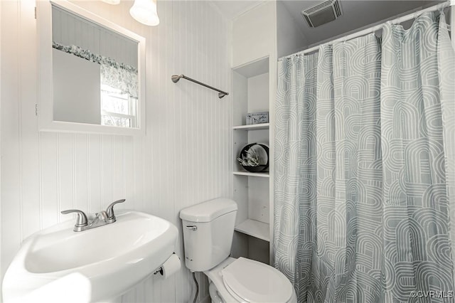 full bathroom featuring curtained shower, visible vents, a sink, and toilet