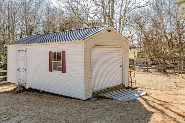 view of outdoor structure featuring an outbuilding and fence