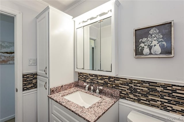 half bathroom with toilet, ornamental molding, decorative backsplash, and vanity