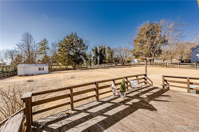 wooden terrace featuring an outdoor structure and fence