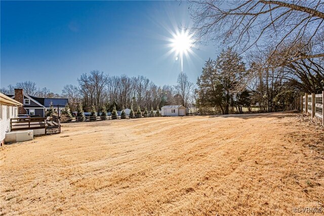 view of yard with an outdoor structure, fence, and a shed