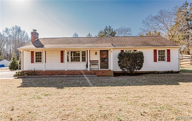 ranch-style home with a front yard, a chimney, and entry steps