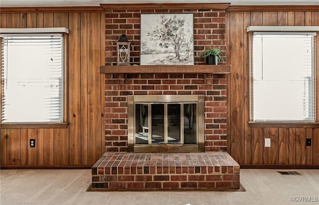 interior details with carpet, a fireplace, and wooden walls