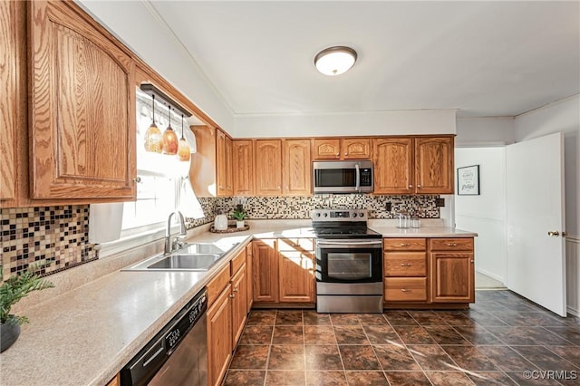 kitchen featuring stainless steel appliances, light countertops, a sink, and tasteful backsplash