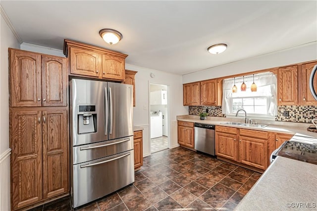 kitchen featuring appliances with stainless steel finishes, decorative backsplash, a sink, and light countertops