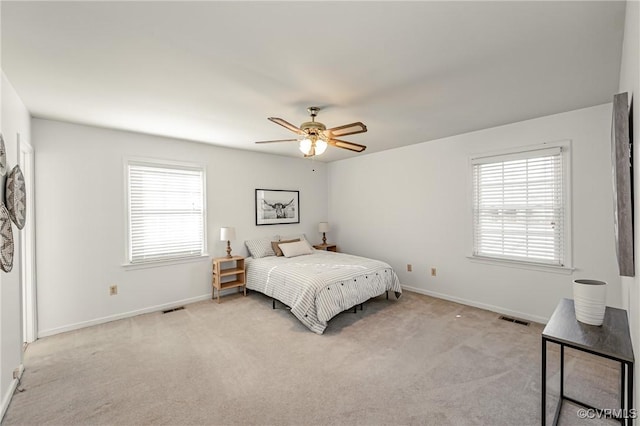 bedroom featuring multiple windows, visible vents, and light colored carpet