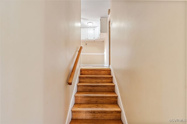 stairway featuring wood finished floors and baseboards