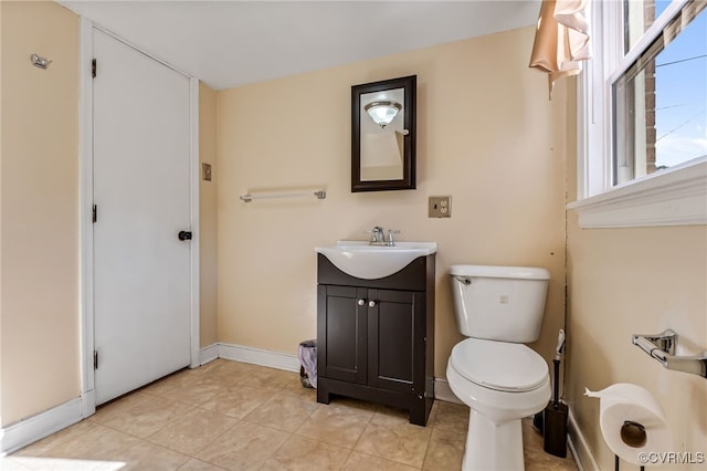 bathroom featuring toilet, tile patterned floors, baseboards, and vanity