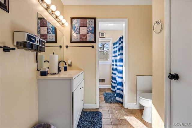 bathroom with curtained shower, toilet, visible vents, vanity, and baseboards