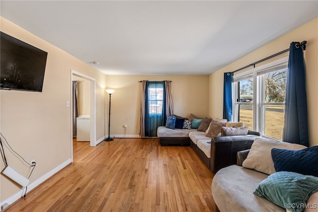 living area featuring light wood finished floors and baseboards