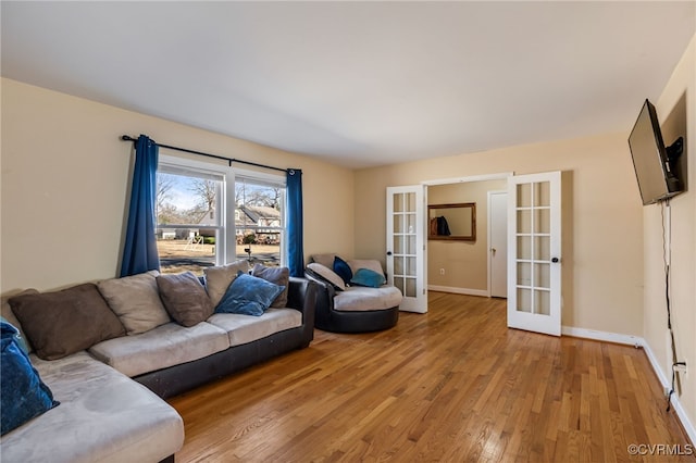 living area featuring french doors, light wood-style flooring, and baseboards