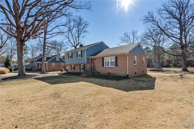 view of front of house with crawl space, a front yard, a chimney, and brick siding