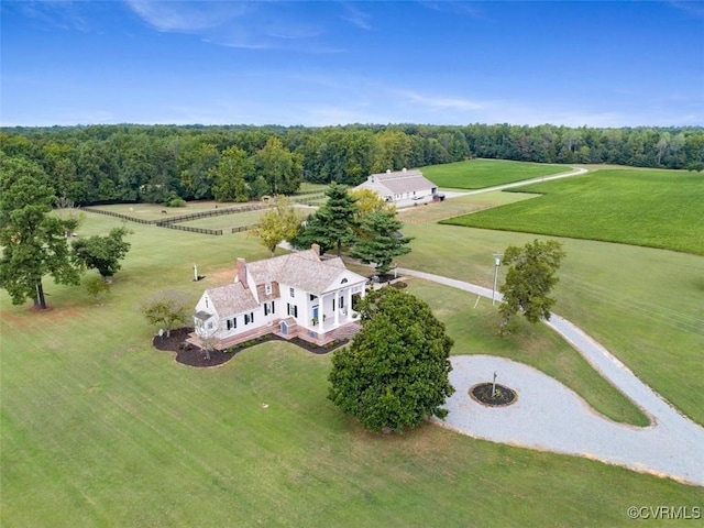 drone / aerial view featuring a view of trees and a rural view