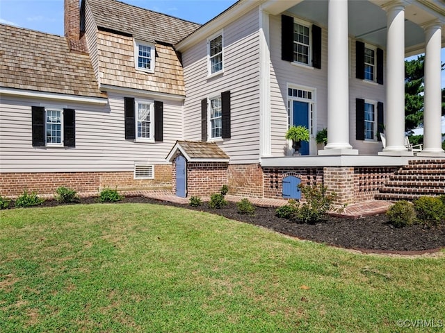 exterior space with covered porch, a chimney, and a yard