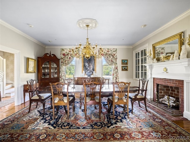 dining room with a chandelier, ornamental molding, a fireplace, and wood finished floors