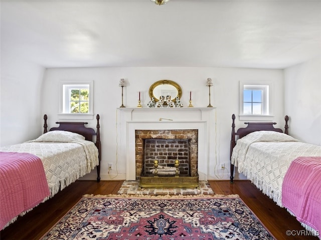 bedroom with a fireplace and wood finished floors