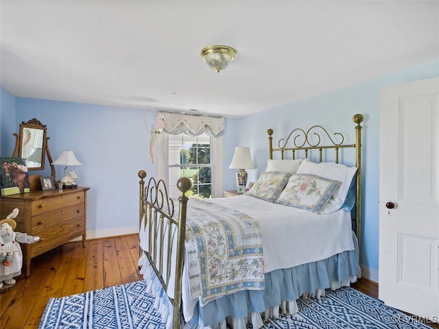 bedroom featuring wood finished floors and baseboards