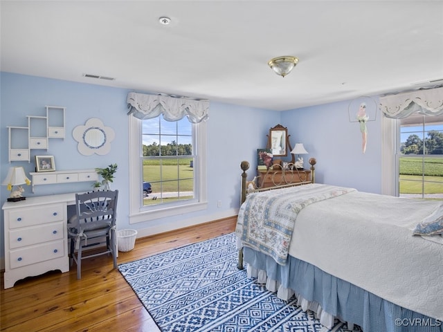 bedroom with hardwood / wood-style flooring and visible vents