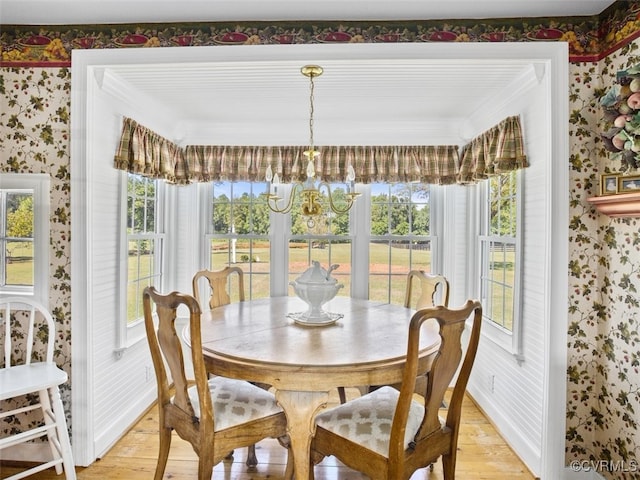 dining room featuring light wood-style floors, an inviting chandelier, and wallpapered walls