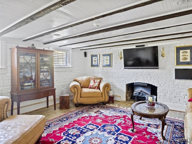 living room with brick wall, a fireplace, and baseboards