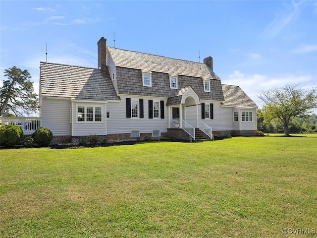 back of property with a chimney and a yard