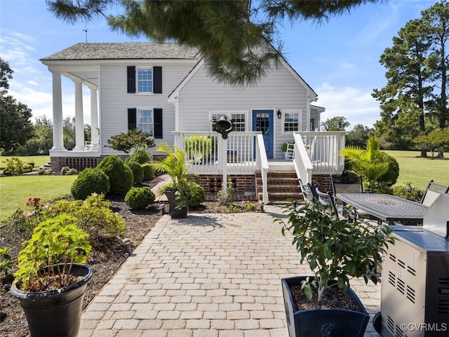 rear view of house with a yard, a patio area, and a wooden deck