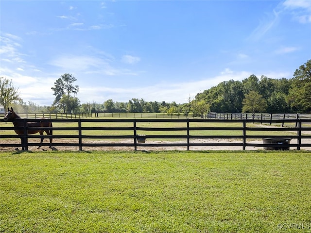 view of gate featuring a rural view and a lawn