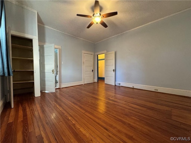 unfurnished bedroom with ornamental molding, hardwood / wood-style floors, a textured ceiling, and baseboards