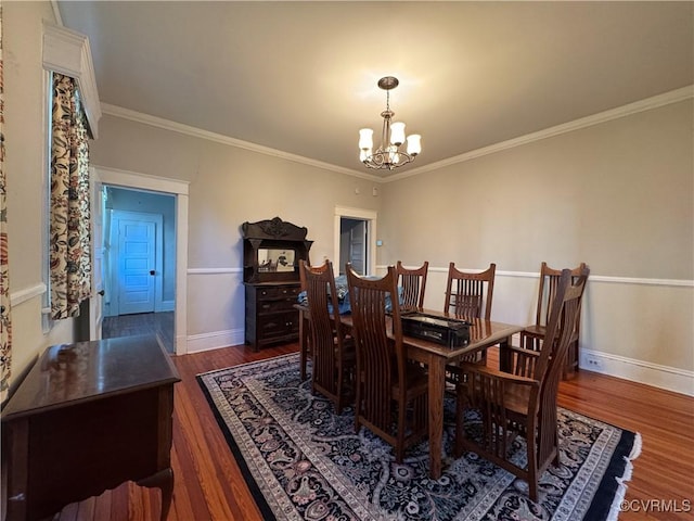 dining space featuring crown molding, a notable chandelier, baseboards, and wood finished floors