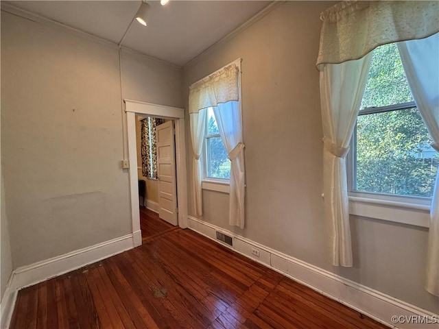 unfurnished bedroom featuring ornamental molding, visible vents, baseboards, and hardwood / wood-style flooring