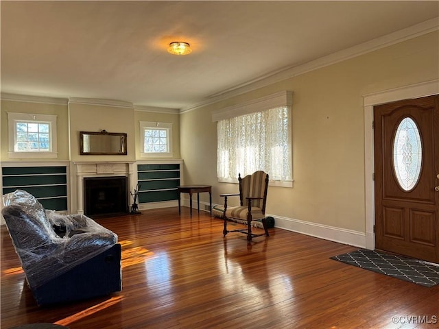 entrance foyer with a fireplace with flush hearth, crown molding, plenty of natural light, and hardwood / wood-style floors