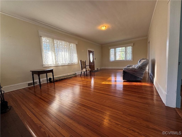 interior space with ornamental molding, hardwood / wood-style flooring, and baseboards