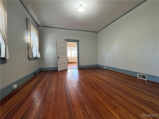 unfurnished room with hardwood / wood-style flooring, baseboards, and visible vents