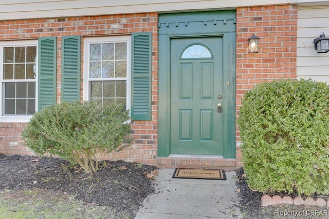 doorway to property featuring brick siding