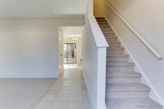 staircase with baseboards, carpet floors, an inviting chandelier, and tile patterned floors