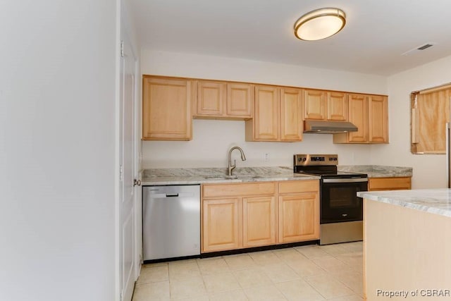 kitchen featuring light stone counters, under cabinet range hood, a sink, appliances with stainless steel finishes, and light brown cabinetry