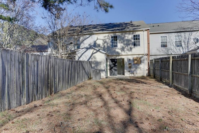 rear view of house with a fenced backyard