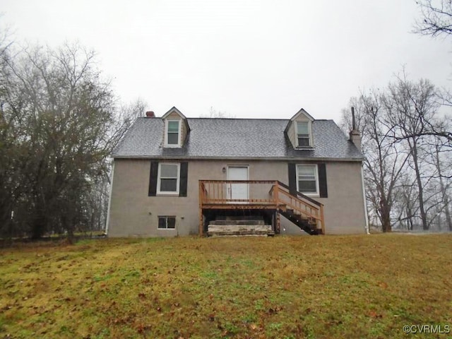 rear view of house featuring stairs, a yard, a chimney, and stucco siding