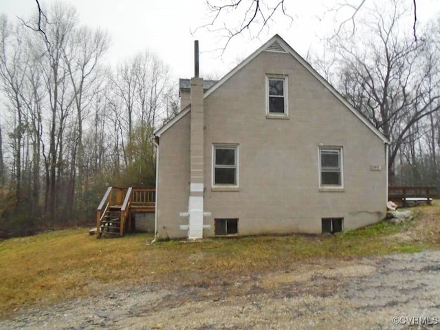 view of side of property with stairway and a chimney